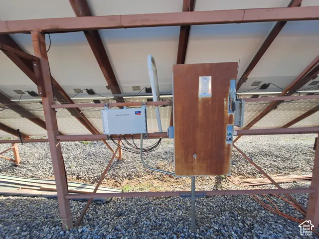 Ground-mounted solar array featuring photovoltaic panels, a metallic support frame, and an electrical combiner box (Inverter not working)
