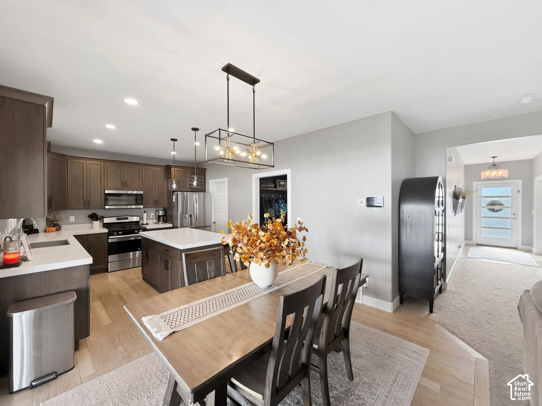 Kitchen featuring shaker-style cabinetry, quartz countertops, stainless steel appliances, a center island, and wood-finish flooring