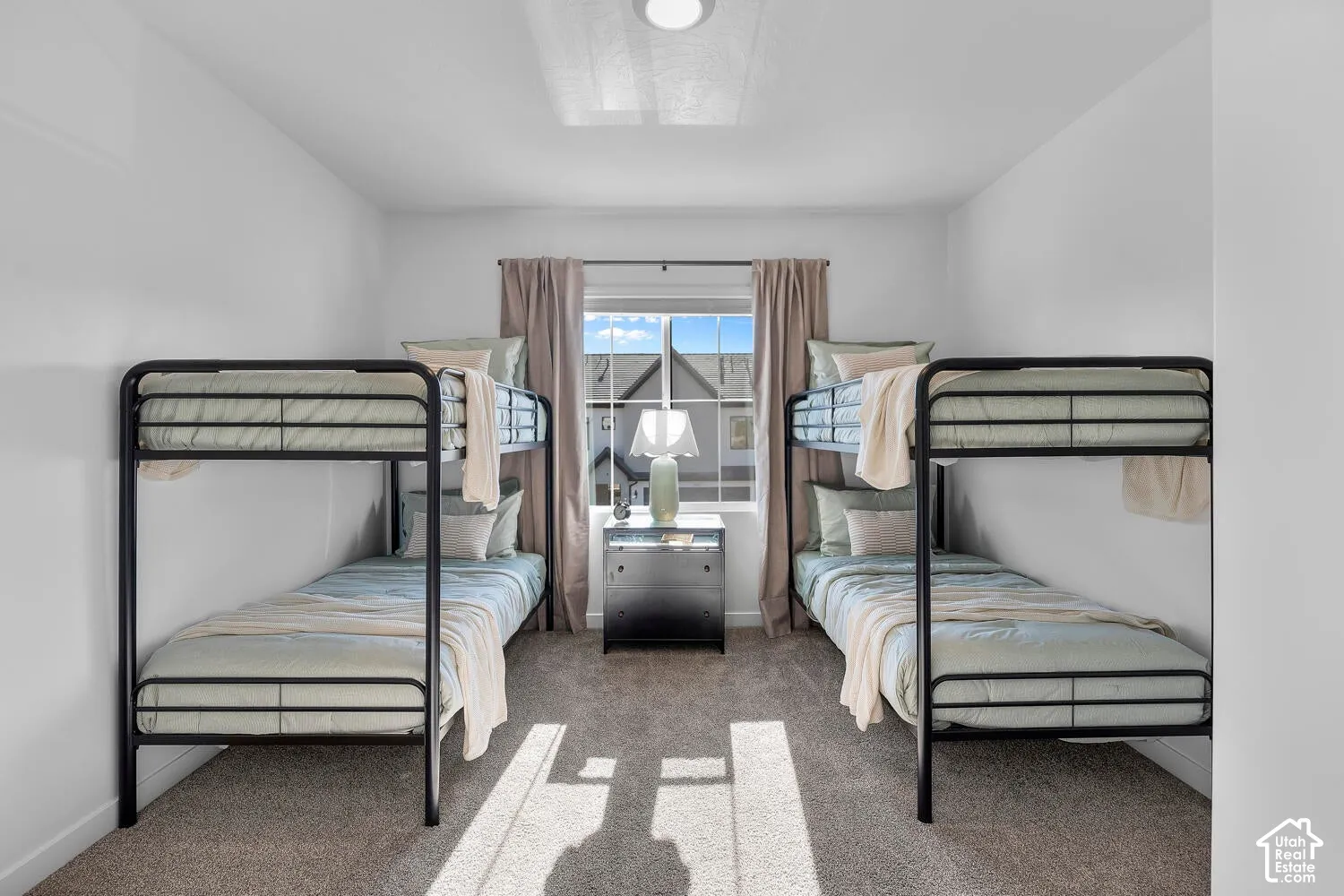 Neutral carpeted flooring, single-pane window with central placement, and recessed ceiling lighting