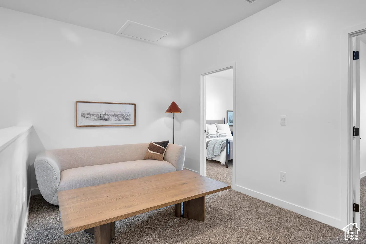 Interior space featuring neutral wall tones, textured carpeting, and high-contrast interior door framing