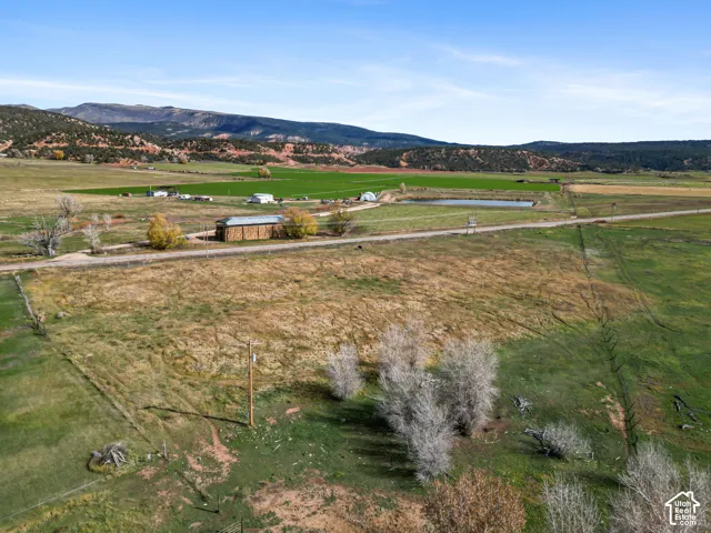 Expansive acreage featuring mature trees, fenced boundaries, and prominent mountain backdrops