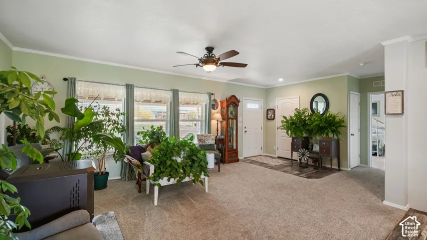 Open-concept interior featuring wall-to-wall carpeting, a multi-pane window configuration, recessed ceiling lighting, and an integrated ceiling fan