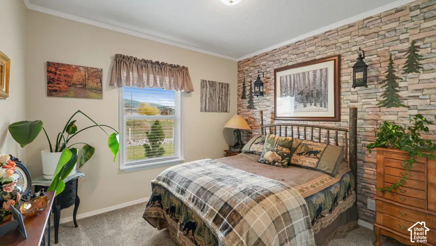 Stone veneer accent wall featuring rustic lantern-style sconces and carpeted flooring