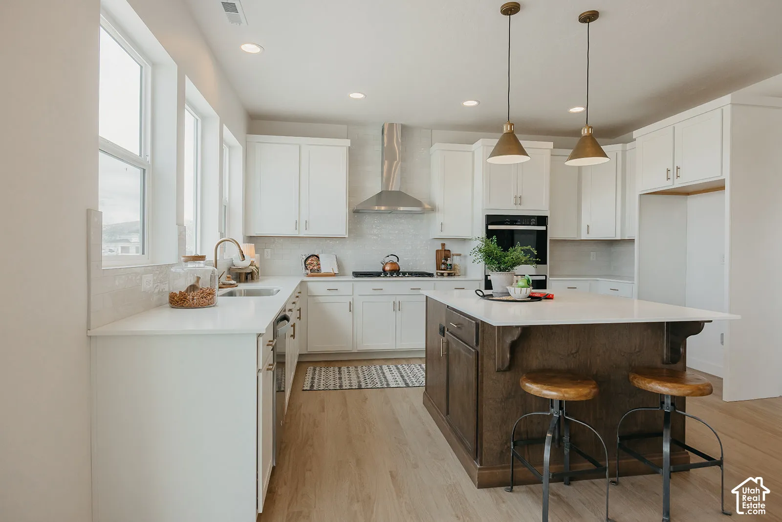 Kitchen featuring white cabinetry, quartz countertops, a central island with wood-finish cabinetry, recessed lighting, and stainless steel appliances