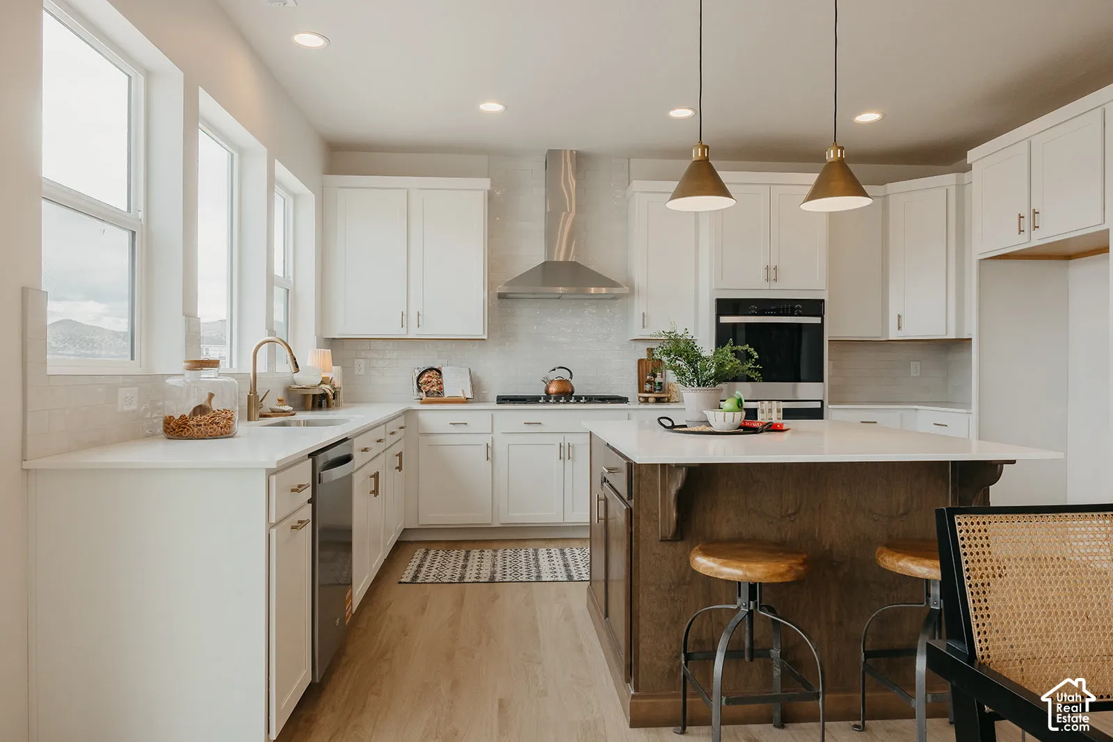 Kitchen featuring shaker-style cabinetry, a central island with wood finish, stone countertops, stainless steel wall-mounted oven, and recessed lighting