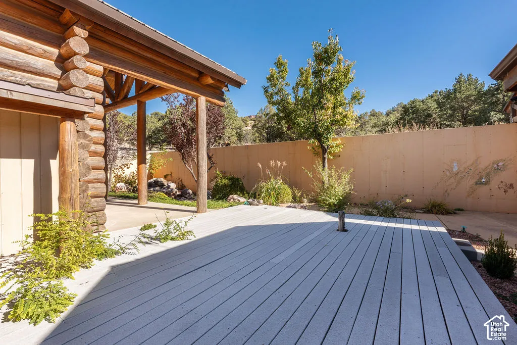 Log-style exterior featuring a covered patio, and composite decking