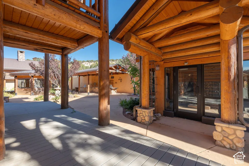 Pool house featuring log-style exterior with stacked-stone column bases, and a glass-paneled entry door