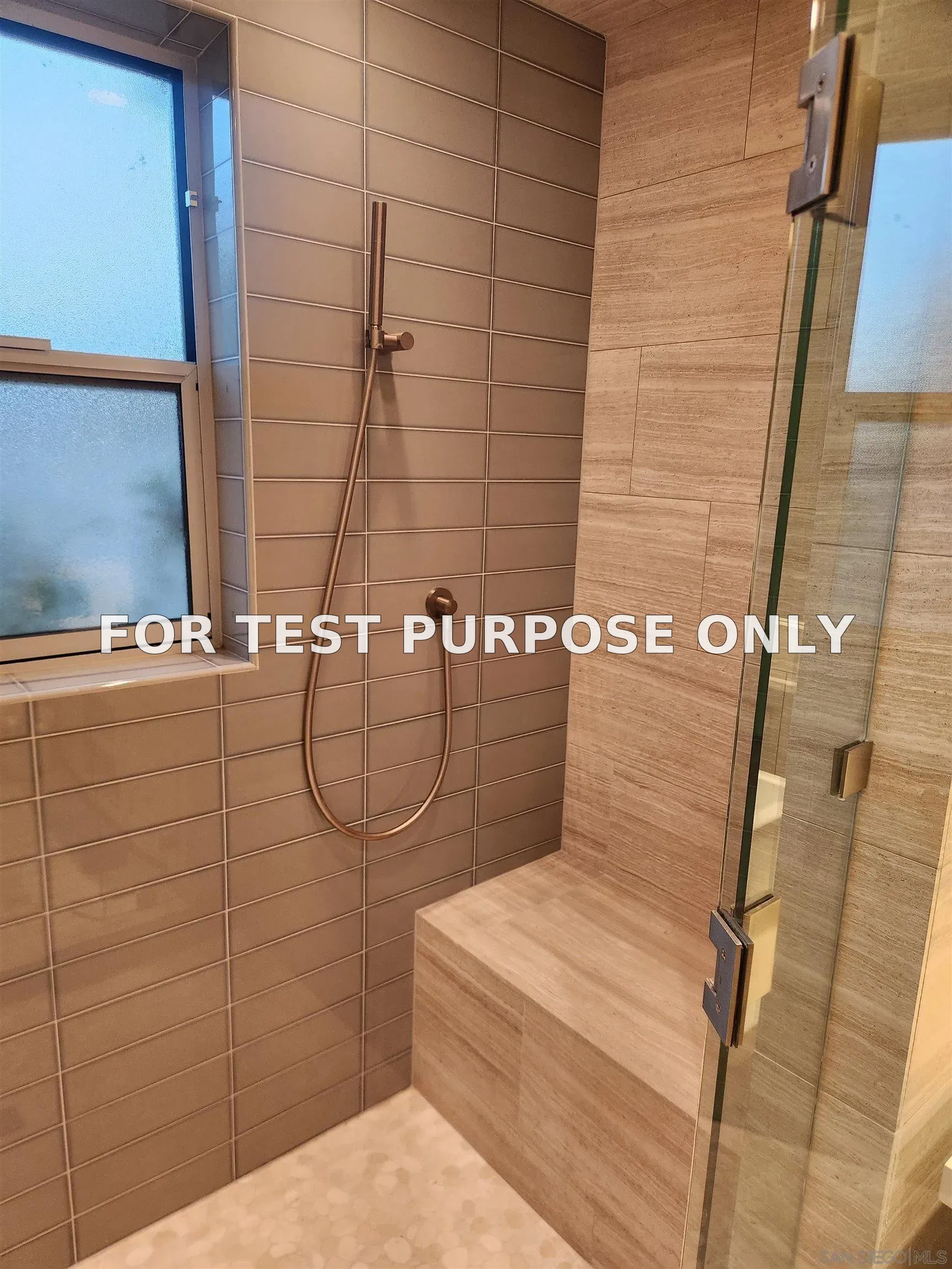 The luxurious walk in shower has benches on both sides, a hand held hand shower head and a washing wand too.