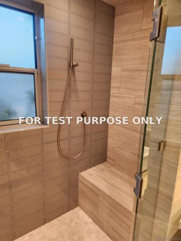 The luxurious walk in shower has benches on both sides, a hand held hand shower head and a washing wand too.