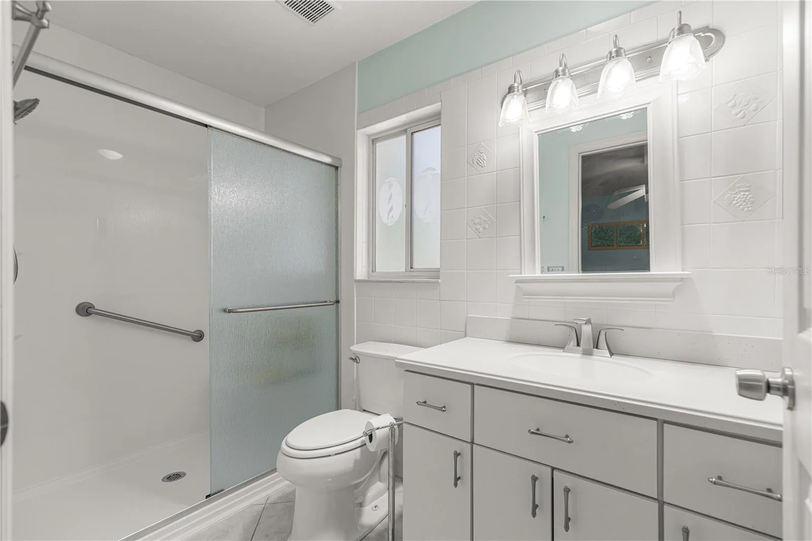 PRIMARY BATH. SHOWER HAS A BENCH SEAT GRAB BARS.
