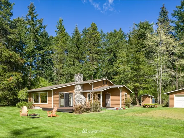 ON THE WEST SIDE, down a wooded drive sits this remodeled 2 bedroom, 2 bath home on 6 acres with 323 ft of frontage. A very private, serine setting yet close to the Village. Walls of windows afford views all the way to the Olympic Mtns + ferry traffic & beautiful sunsets.
