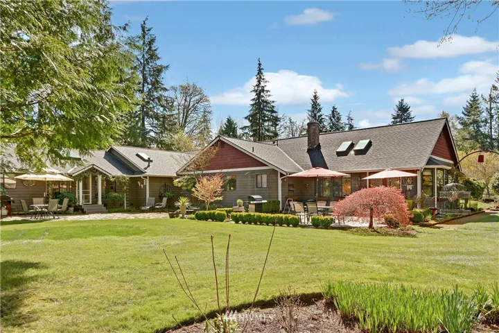 Rear view of home showing both the newer and original sides of the home and the 2 back adjoining patios.