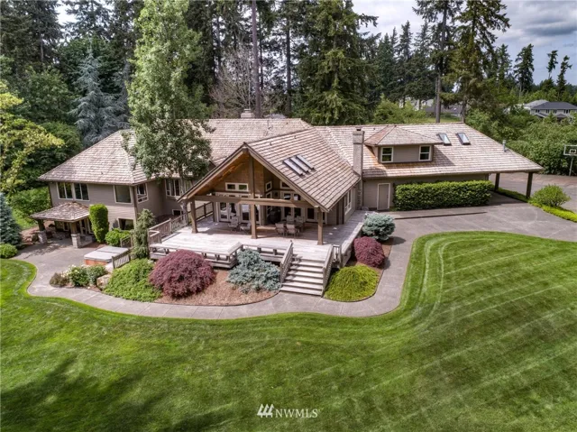 Picturesque property and residence surrounded by manicured landscaping and Evergreens.