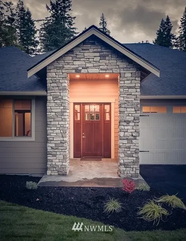 Grand front entry with solid custom wood door welcomes you home.