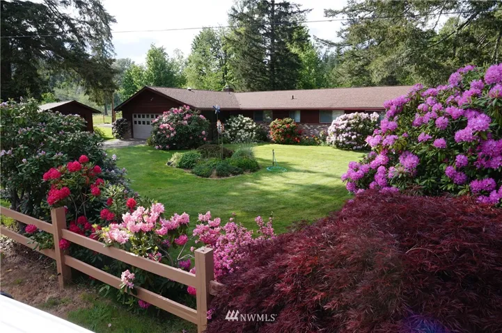 Front of house, concrete driveway, brick siding, new paint, with lots of Rhododendrons and other shrubs and treees. Remodel, complete HVAC system, real hardwood floors, roof in 2005. Dual pane windows install date unknown.