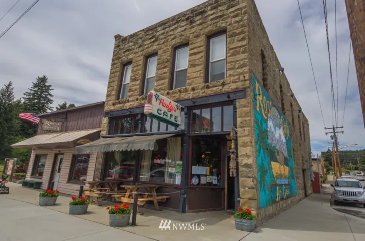This restored landmark sandstone building sits on the corner of Pennsylvania and Second St in historic downtown Roslyn, WA. The building which now is home to the Roslyn Café was built in 1896 out of large blocks of sandstone from a local quarry. A large building, it is two stories high and extends at least one half block away from the main street. The first owner started a general merchandise and liquor store. It then became a series of butcher shops in the early 1900’s under different managers. Many of the fraternal orders organized by the miners had their meeting hall in the upstairs. There was an upright piano and a closet full of hats, flags and paraphernalia for the different groups. The Druids, the Knight of Pythius, Dr.Starkovich’s Order, the Elks, Eagles and many others locals met there.