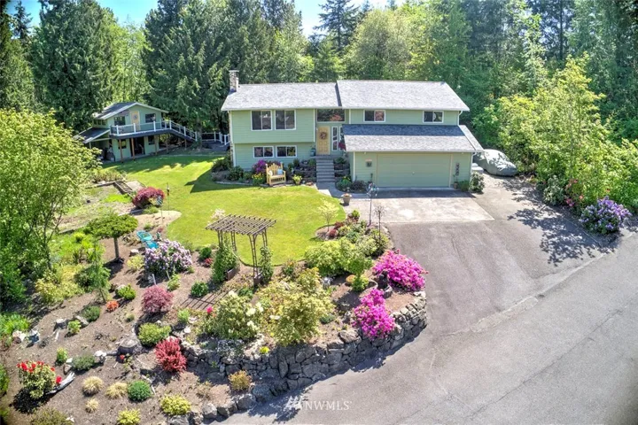 Welcome to Benson Hill and a hidden gem at the end of a private drive! This spacious home sits on a gorgeous shy acre lot, backing to a greenbelt and featuring a lush landscape. The incredible deck leads to a separate, adorable 2-story outbuilding. Offering the best of Northwest style, comfort, and abundant light, you’ll be drawn to the warm and inviting living room that showcases a lovely Arizona Sandstone fireplace. The incredible kitchen has been recently remodeled with granite & stainless steel finishes, white cabinets and upgraded features that delight at every turn. You’ll love the double ovens, pantry cabinets and buffet counter. The open-concept provides for easy entertaining and the large slider will draw you outside where you can extend your living and entertaining to the tranquil, expansive deck. This amazing feature is newly installed and connects to the 2-story outbuilding which features a deck of its own!
