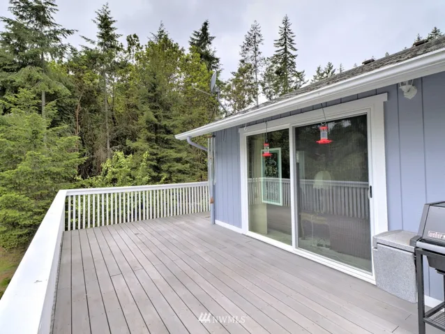 1040 sq ft composite partial wrap deck with slider from dining room overlooks lower level landscaped yard and adjacent lot include with house for extra privacy.
