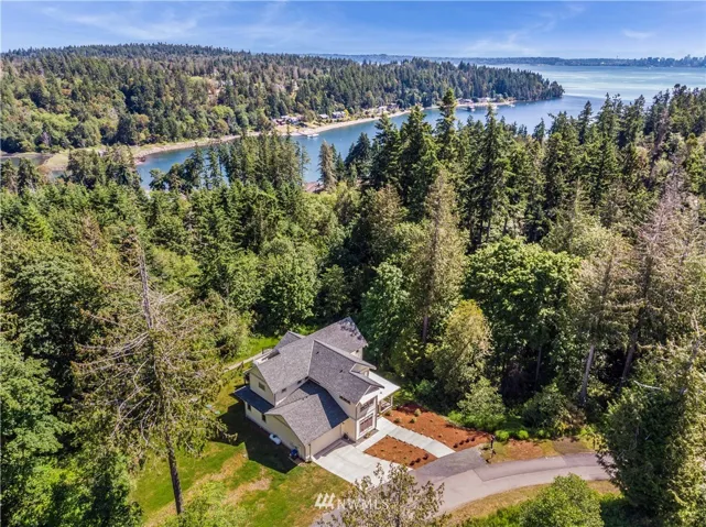 Aerial view of home backing up to 64 acres of designated open space with meandering trails leading to Port Blakely (shown here).