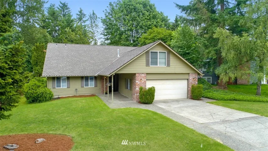 Classic brick and cedar home with an extended driveway leading to an inviting covered entry.