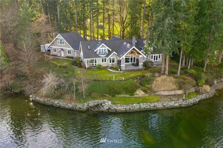 Welcome home through the private gated entry, drive along the cherry blossom tree lined circular driveway to this private 4.6 acre 650 ft waterfront enclave retreat. Recently remodeled architectural home is traditional w/sophisticated northwest casual elegance. Master suite on main, 3 guest en suites on upper level and separate entry guestroom over garage.  Shared deep water dock. Separate boat house/shop/barn/ water sport storage. 2 garages for plenty of room for multiple cars.