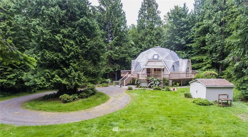 View of large shed and home with circular driveway