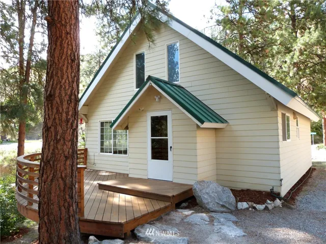 Main entrance of this quaint home with unique cedar deck.