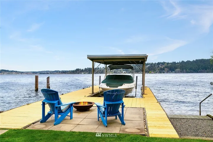 Property boasts large dock, boat lift, deep water moorage, and covered boat slip