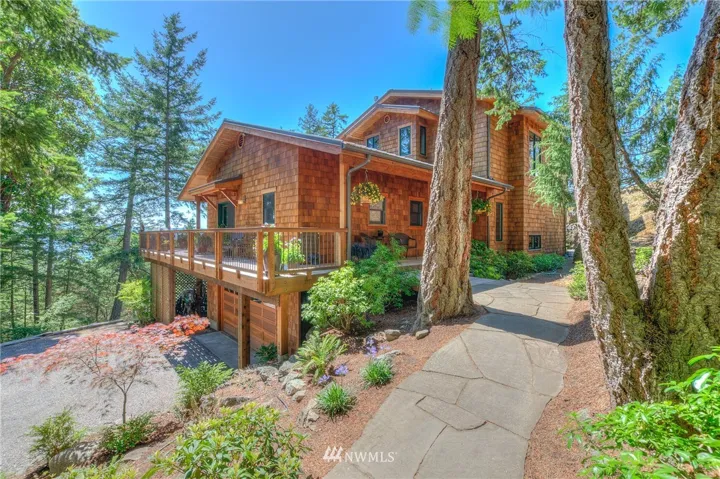 Entrance to the 2+ acre property. Front door is behind the Fir next to the path. Attention to detail is apparent in the overall construction of this home as you approach. Wrap around main floor deck allows the most comfortable outdoor seating depending upon the time of day. Landscaping is irrigated from a water catchment system and is low maintenance & drought resistant. Energy efficiency of the stacked-floor design and optimum sun orientation - windows capture winter sun with overhangs that minimize summer heat.