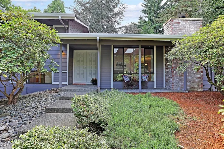 Such a welcoming entry in a very natural setting within a mature landscape. Enjoy your morning coffee on the charming front porch!