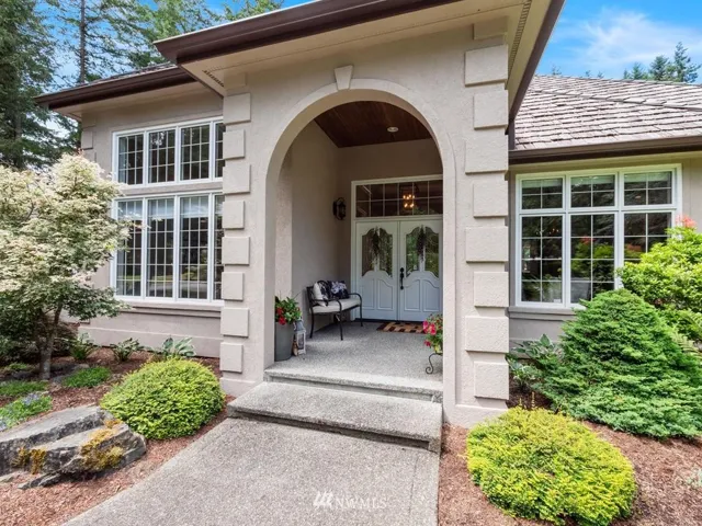 Gracious entrance to this main level living luxury residence. Covered entry protects guest in all weather with natural wood ceiling detailing and beveled glass doors. Large corner property with circular driveway and garage entrance in rear of home with private driveway.