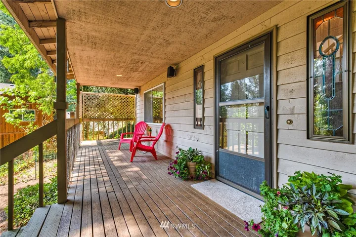 Large covered front porch is perfect to sit and take in the views and quietness of the property! 6 panel solid wood entry door with cute stained glass windows on each side.