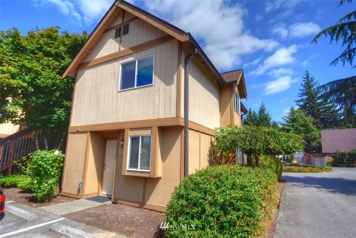 The entry to this 2 story end unit. There is even a small flower bed in front to grow some flowers or plants.  Like the rest of the complex, this unit has a new roof, has been painted and is in good shape!  Unlike most of the other units, this has new double pane vinyl windows  which combined with heat pump make the incredibly energy efficient and cheap to operate.