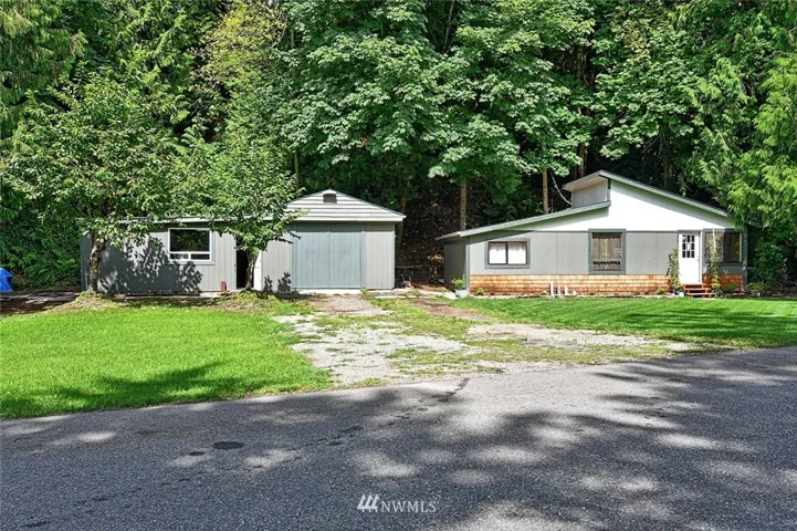 Front view of home with one garage and shop with additional storage on the left hand side