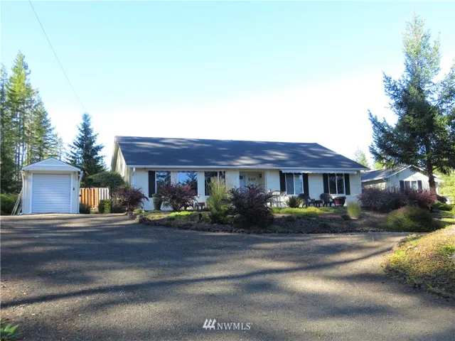 Front exterior - Golf cart garage at left, detached garage off to the right