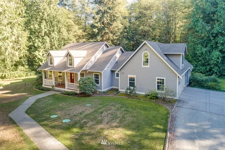 Spectacular Custom Home nestled on 5 private acres! Charming covered front porch!