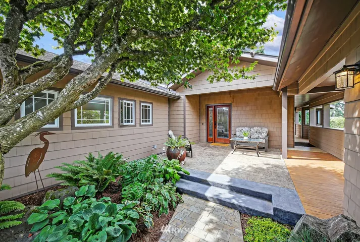 Lovely, hidden entrance to this amazing home. Covered walkway from 2 car garage to both front door and side door to kitchen. Stamped concrete, professionally landscaped...