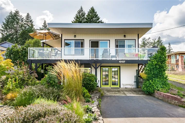Inviting home with wrap deck for relaxing and entertaining. Open the slider and French doors for a pleasant breeze.