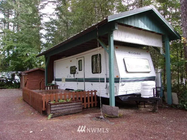 Nestled amongst the trees and under cover is this very nice 27' 1998 Wilderness travel trailer with a slide out.  RV cover has a metal roof.