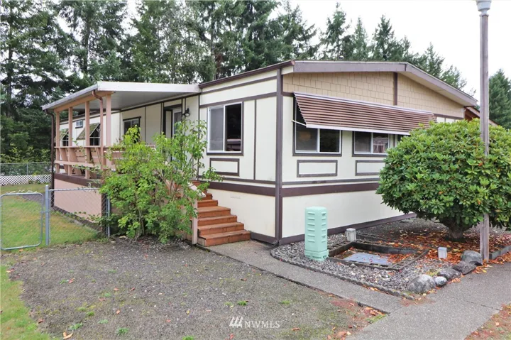 Terrific manufactured home in 55+ Friendly Village, with 4 bedrooms and some privacy in back!