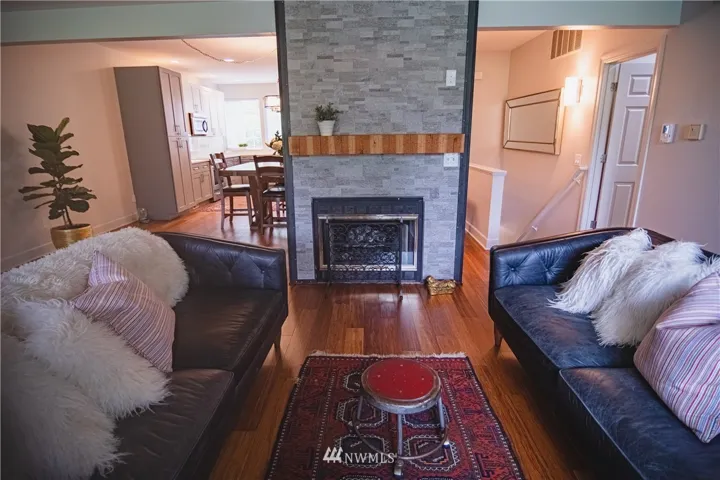 Living room with cozy fireplace and looking through to dining and kitchen.