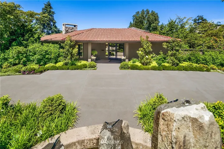 The front of the home:  handsome landscaping, a circular driveway and a beautiful stone fountain welcome you...