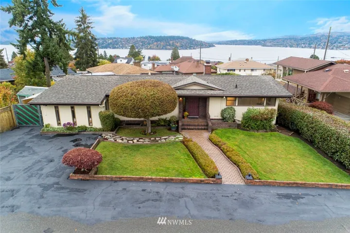 Drone view of the front of home.  Plenty of parking for extra cars.  Left side 3 windows was previously a carport and now converted into a shop or mud room.  Wired/Plumbed for washer & dryer.  Behind green/brown gate RV or Boat Parking.