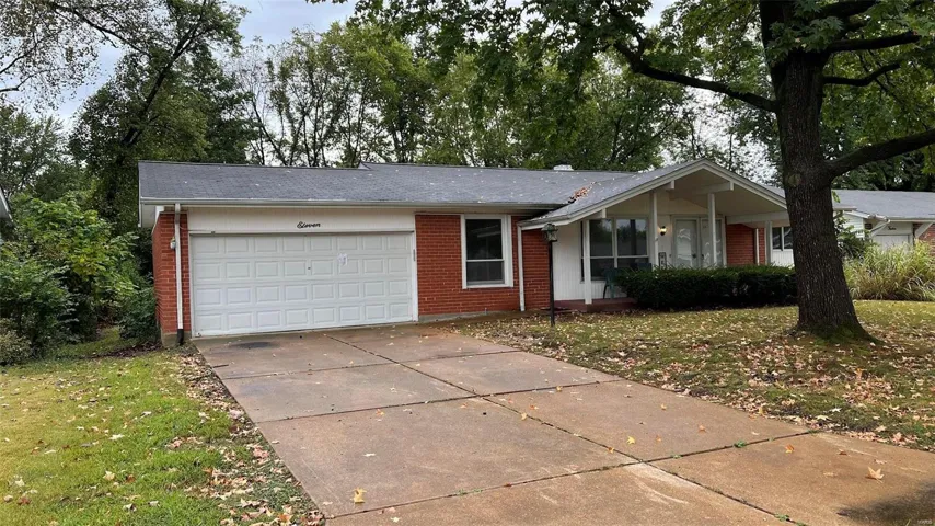 Single story home with a garage and a front lawn