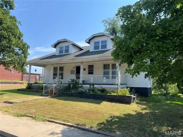 View of front of property with a porch and a front lawn