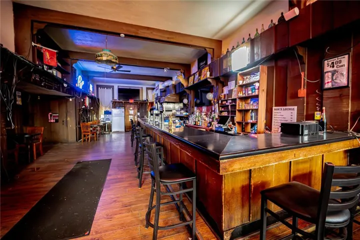 Indoor dry bar featuring wood finished floors, freestanding refrigerator, and ceiling fan