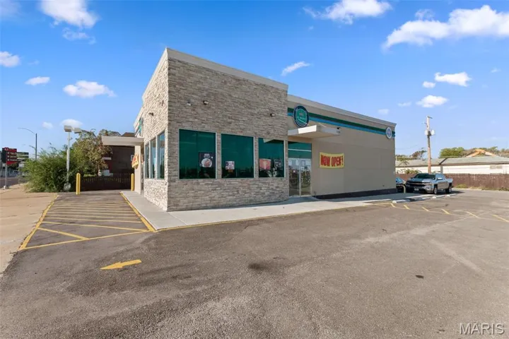 View of property featuring uncovered parking