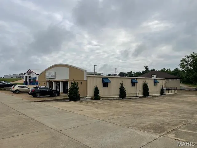 View of property featuring uncovered parking