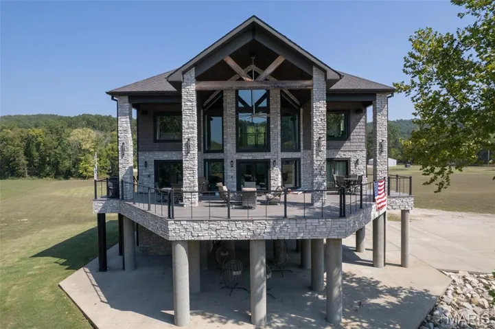Rear view of house featuring a lawn, a patio, and a wooden deck