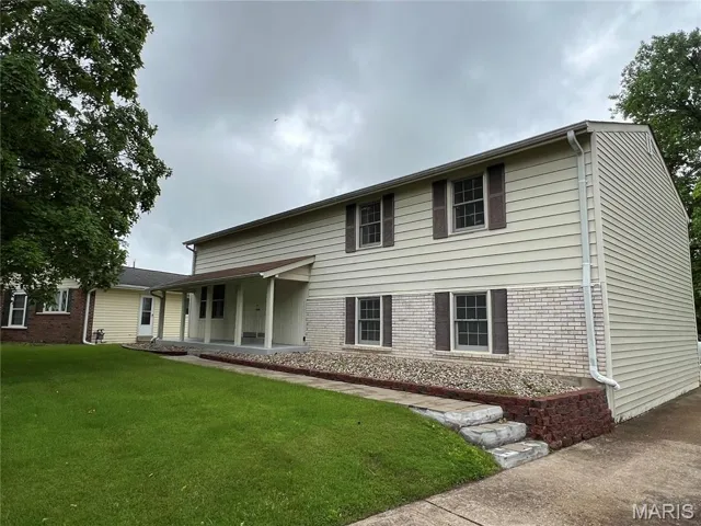 View of front of home with brick siding and a front yard